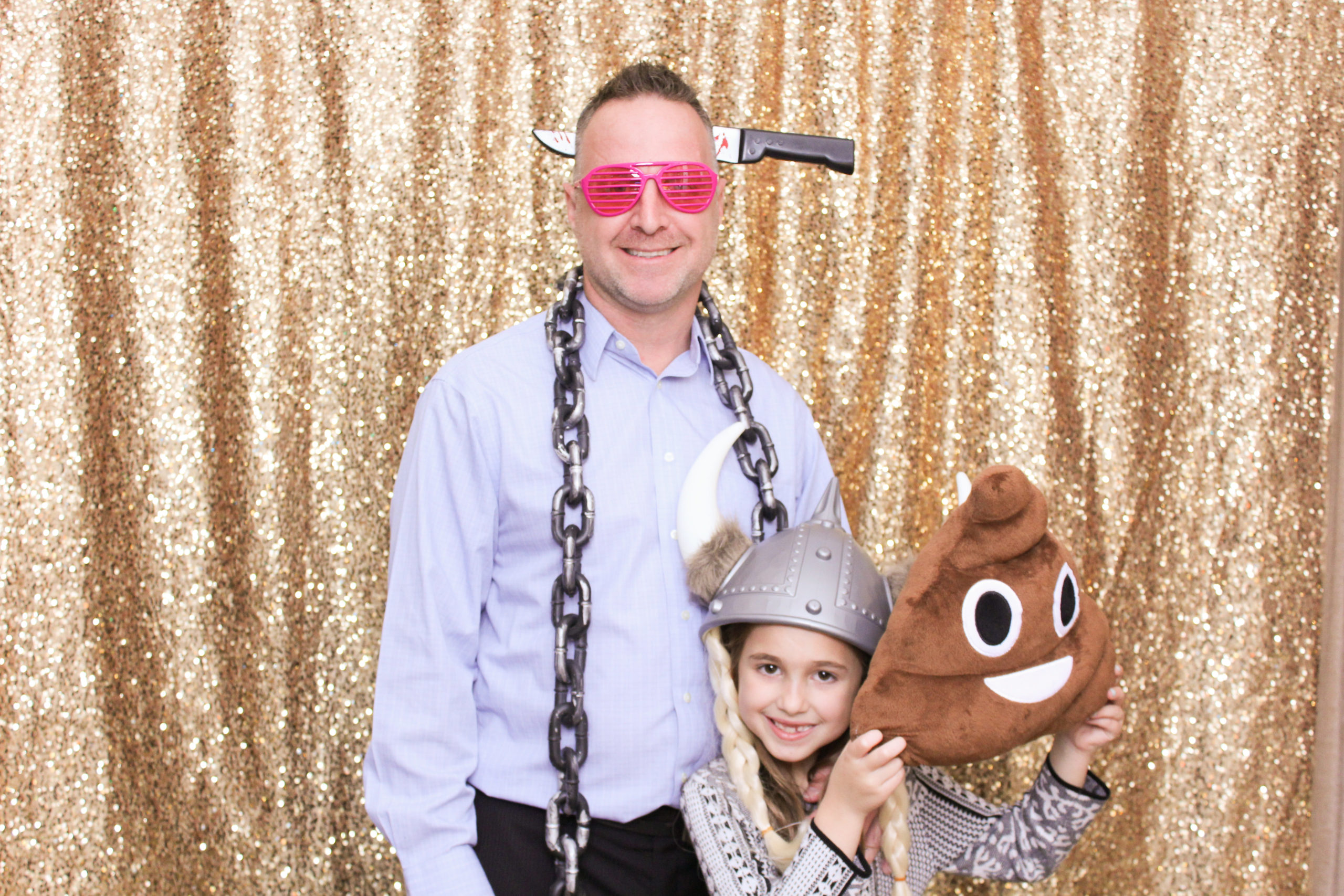 A dad and his daughter using props to have fun in a photo booth rental.