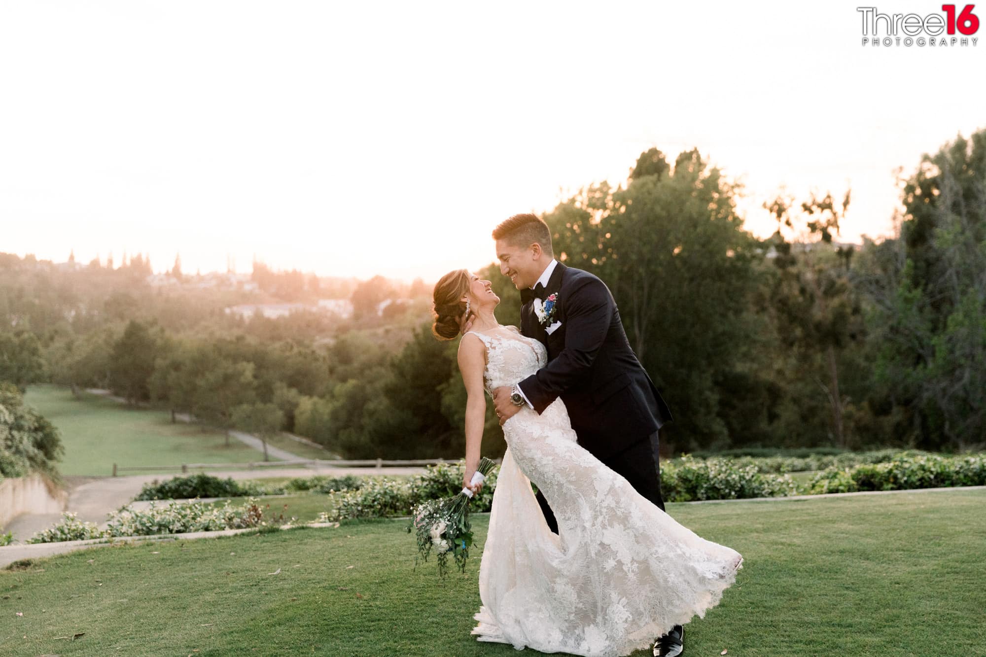 Groom dips his Bride and smiles on the golf course at the Anaheim Hills Golf Course wedding venue in Anaheim Hills.